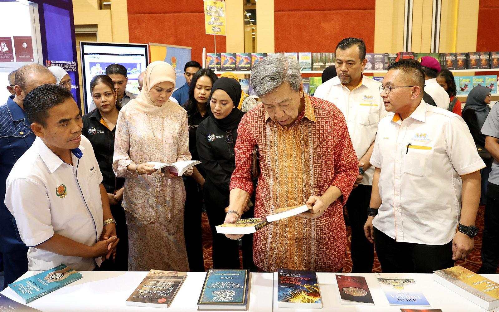 Baginda berdua membelek naskhah buku yang dipamerkan semasa lawatan ke Pesta Buku Antarabangsa Kuala Lumpur (PBAKL) 2026.